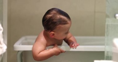 Adorable baby toddler inside bathtub smiling acting cute