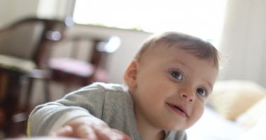 Cute baby child face wanting to touch camera lens reaching arm