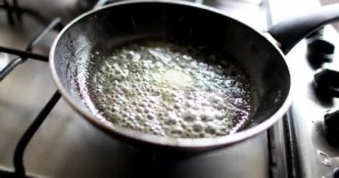 Yağlı tavada yumurta kırıyorum.