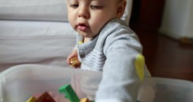 Cute baby toddler grabbing toy from box
