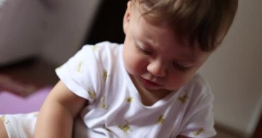 Adorable cute baby playing with camera lens cap. Toddler infant teething bitting object