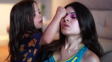 Annesine makyaj yapan bir kız. Küçük kız çocuğu, yetişkin anne samimiyeti ve özgünlüğü için makyaj yapar.