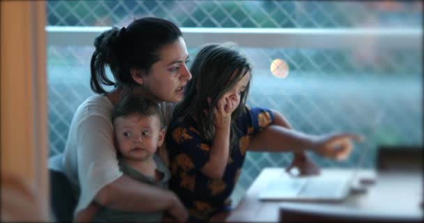 现实生活中的母亲在电脑屏幕前和孩子们在一起 真正的母亲养育女儿和儿子一起指向内容浏览互联网 — 图库视频影像
