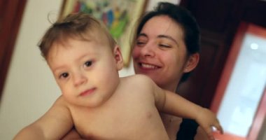 Mother tickling baby infant under armpit with mouth
