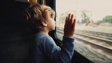 Small boy leaning on window at train transportation