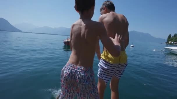 Çocuklar Yaz Tatilinin Tadını Çıkarıyorlar Rıhtımda Duruyorlar Kardeşini Suya Itiyorlar — Stok video