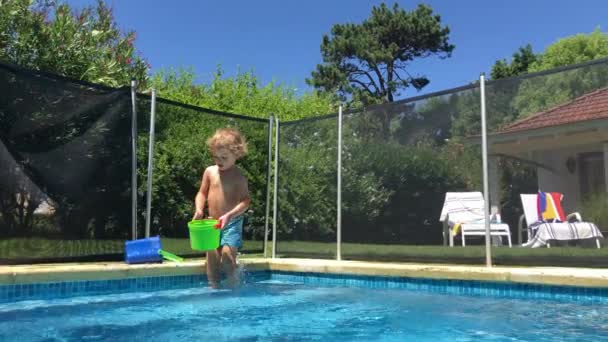 Toddler Boy Entering Swimming Pool Playing Bucket — Stok Video