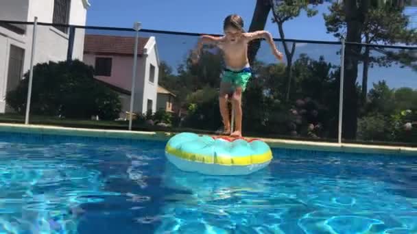 子供は水泳プールでインフレータブルマットレスの上にジャンプします — ストック動画