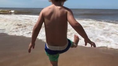 Toddler baby boy playing at the beach, having fun
