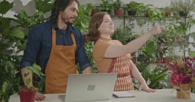 Female employee working at local small business store taking online orders using tablet modern device. Young woman staff managing inventory
