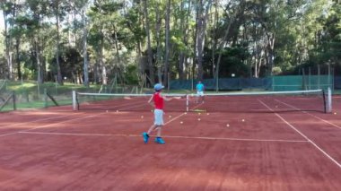 Punta del Este, Uruguay, December 27 2018 - Child practicing tennis with his dad
