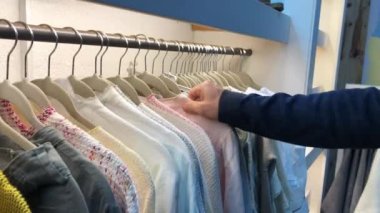 Consumer pulling clothing from hanger