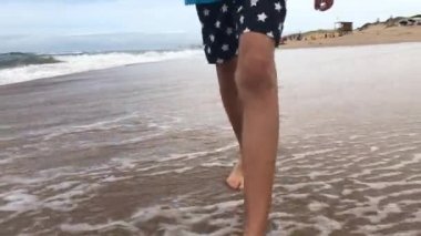 Kid feet walking at beach