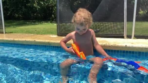 Toddler Boy Holding Toy Gun Swimming Pool Curious — Wideo stockowe