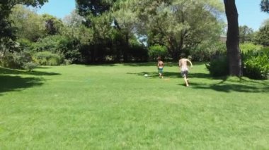 Children playing soccer outside at home lawn