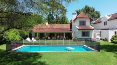 Exterior of suburban home with pool and lawn