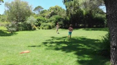 Children playing soccer outside at home lawn