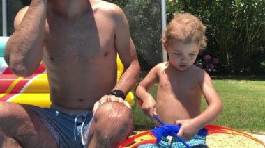 Küçük çocuk okçuluk oyuncağıyla nasıl oynanacağını çözmeye çalışıyor. Çocuk babadan oyuncak için yardım iste.