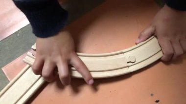 Toddler baby boy playing with wooden toy roads