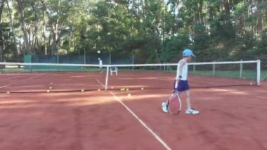 Punta del Este, Uruguay, December 27 2018 - Child practicing tennis with his dad