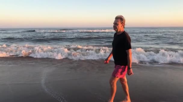 Retired Older Senior Man Walking Beach Shore Sunset Contemplative Meditative — Vídeo de Stock