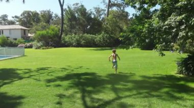 Children running outdoors in home garden during beautiful day
