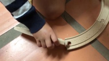 Toddler baby boy playing with wooden toy roads
