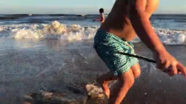 küçük çocuklar kumsalda oynarken