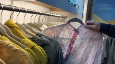 Woman pulling clothing from hanger