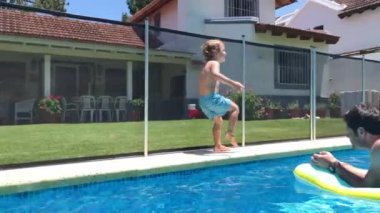 Yüzme havuzu, havuz başında çocuk, havuzda baba.