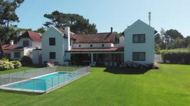 Home house exterior with lawn and swimming pool