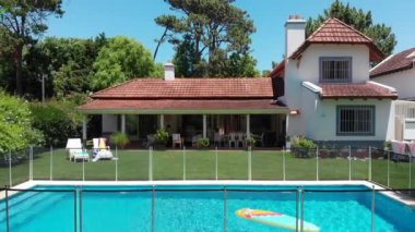 Exterior of suburban home with pool and lawn
