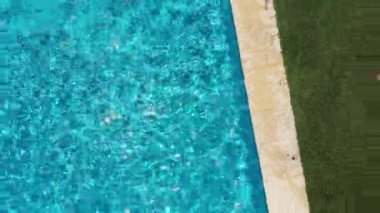 Çocuk yüzme havuzunda koşuyor ve zıplıyor. Dikey hava perspektifi