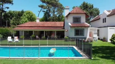 Exterior of suburban home with pool and lawn