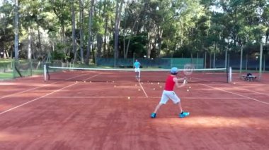 Punta del Este, Uruguay, December 27 2018 - Child playing tennis with his father outdoors