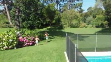 Children running outdoors in home garden during beautiful day