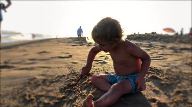 Cute baby boy at the beach shore