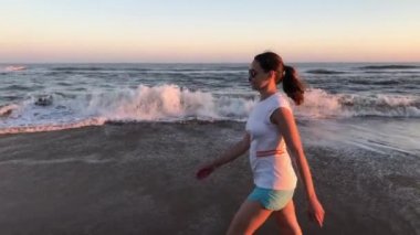 Kumsalda yürüyen genç bir kadın