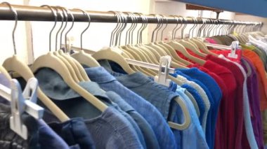 Row of colorful women apparel on shoulder hangers. Wardrobe showcas