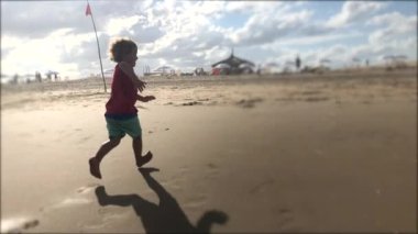 Toddler boy running at the beach