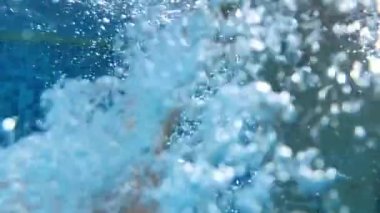 slow-motion of young boy emerging from water