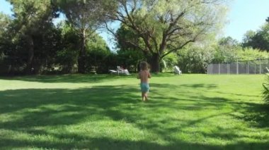 TOddler baby boy running outside in the home garden