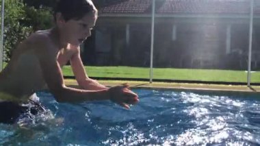 Child boy diving inside swimming pool water