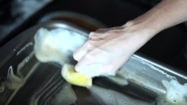 Hands washing dish with soap
