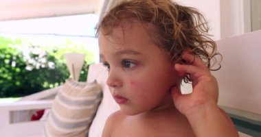 Baby boy laying down on sofa, resting