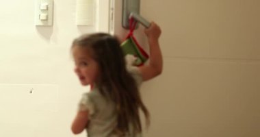 Evin kapısını açan küçük kız Noel Baba 'nın gelmesini bekliyor.