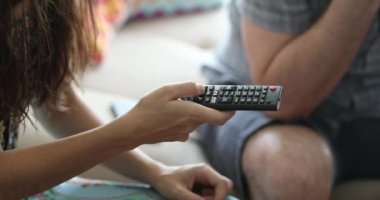 Closeup of woman pressing remote control
