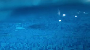 Child jumping inside water pool