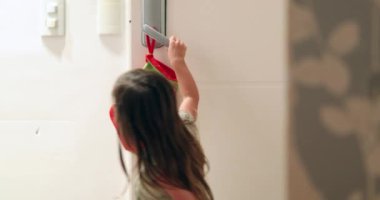 Küçük kız Noel zamanı ön kapıyı açıyor.