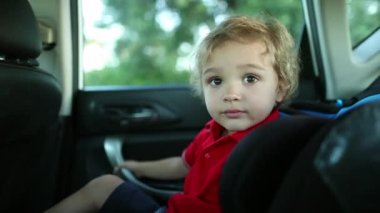 Toddler boy in the backseat of a car